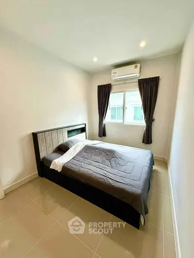 Modern bedroom with sleek design, featuring a comfortable bed and natural light from a window.