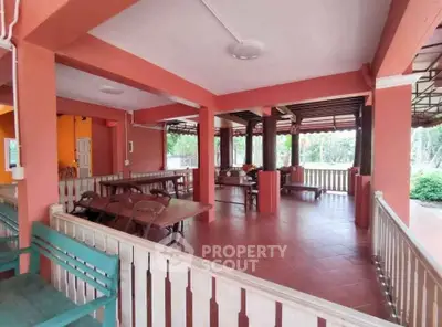 Spacious outdoor terrace with vibrant orange decor and wooden seating, perfect for gatherings.