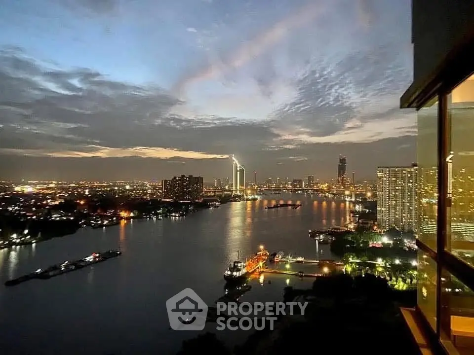 Stunning cityscape view from high-rise apartment balcony at dusk, showcasing vibrant skyline and river.