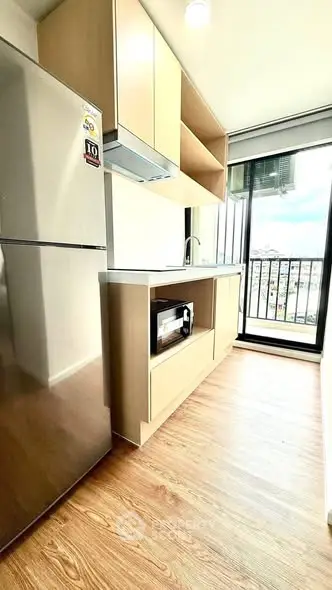 Modern kitchen with sleek appliances and balcony view in a bright apartment.