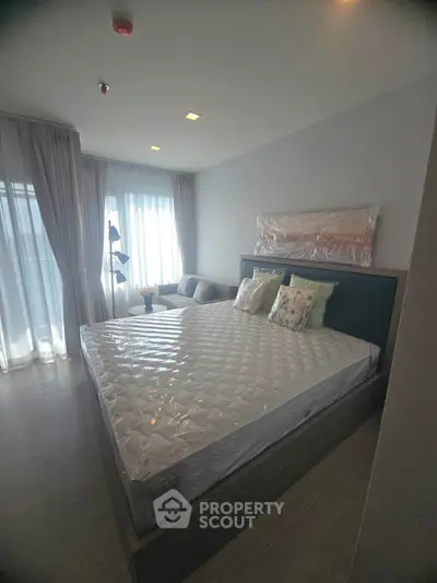 Modern bedroom with large windows and stylish decor in a cozy apartment.