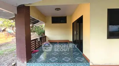 Charming covered patio with tiled flooring and sliding glass doors, perfect for outdoor relaxation.