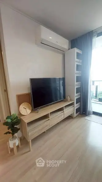 Modern living room with sleek TV stand, air conditioning, and balcony view.
