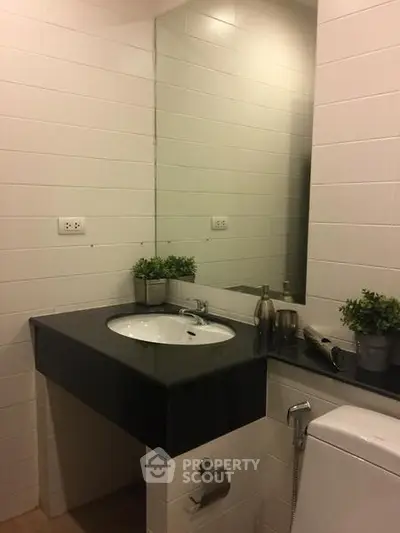 Modern bathroom with sleek black countertop and large mirror