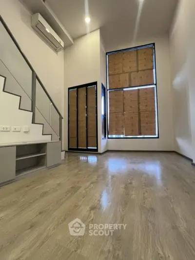 Modern duplex interior with high ceilings and large windows