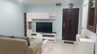Modern living room with sleek furniture and large TV, perfect for relaxation and entertainment.