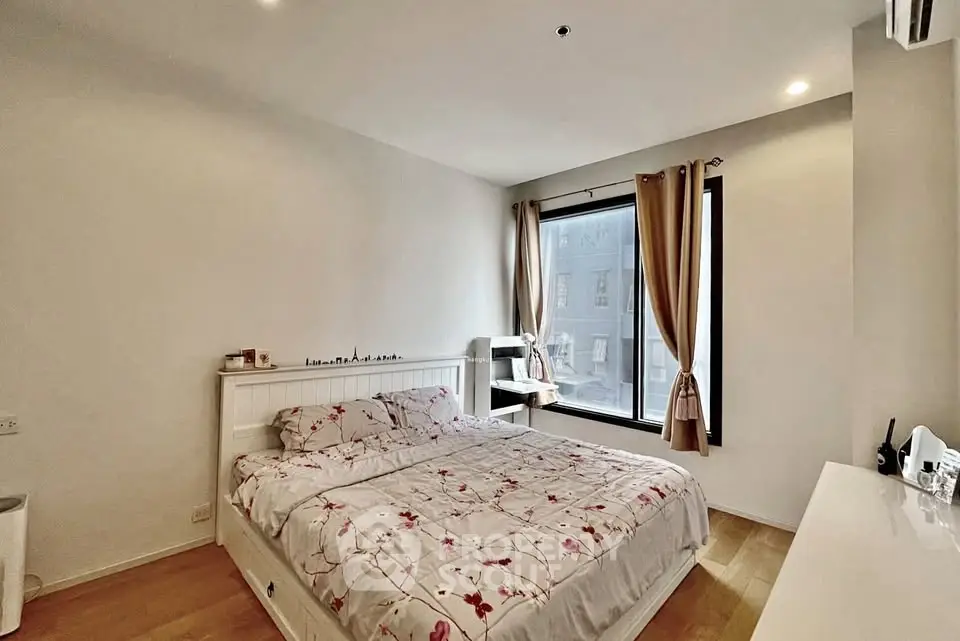 Cozy bedroom with large window and stylish decor in modern apartment