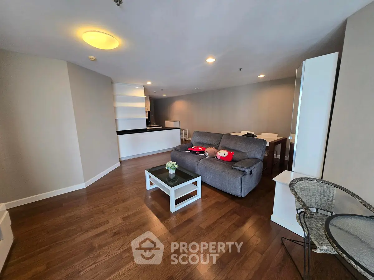 Spacious living room with modern decor and open layout, featuring hardwood floors and cozy seating area.