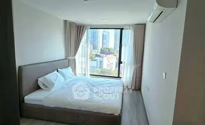 Modern bedroom with large window offering city view, featuring a comfortable bed and sleek design.