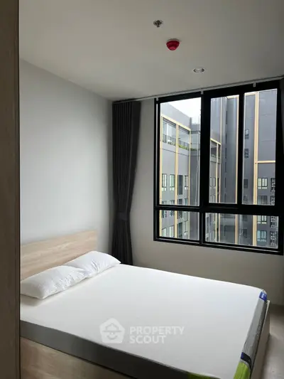Modern bedroom with large window and minimalist design in urban apartment