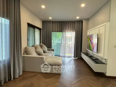 Spacious living room with modern decor and large windows overlooking a balcony.