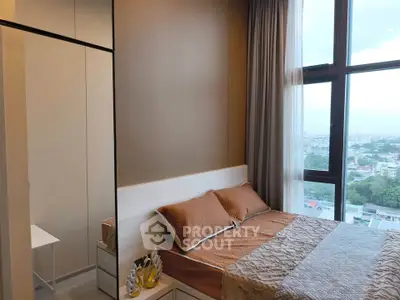 Modern bedroom with large window offering stunning city views and elegant decor.