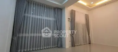 Spacious living room with elegant curtains and modern ceiling lights