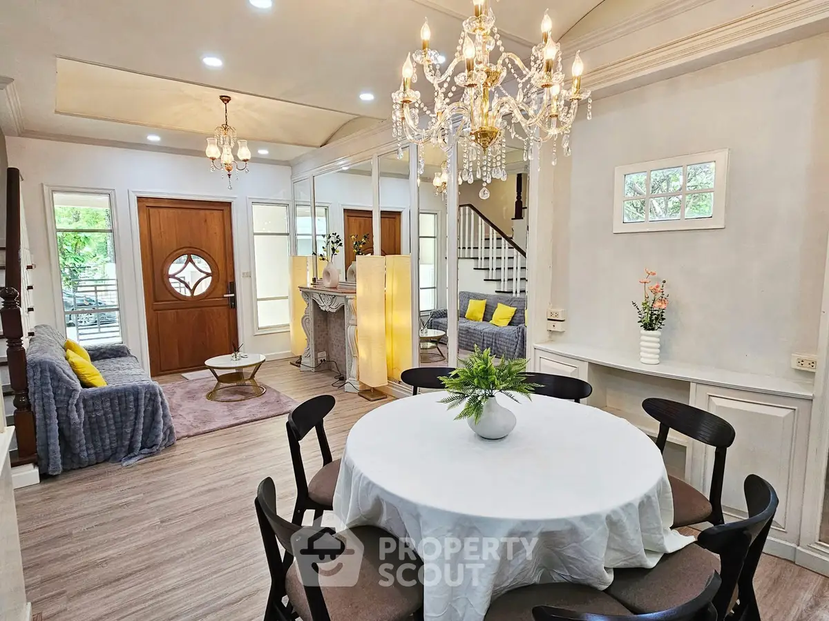 Elegant living and dining area with chandelier and modern decor