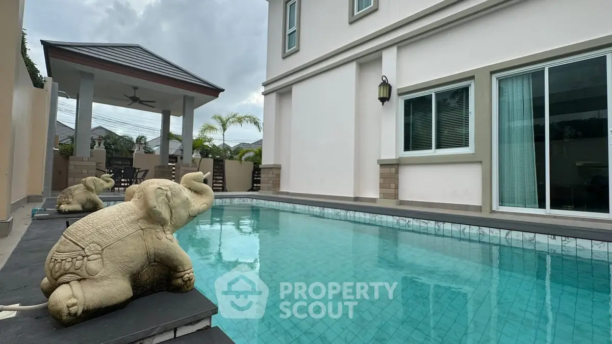 Luxurious home with private pool and elegant outdoor seating area.