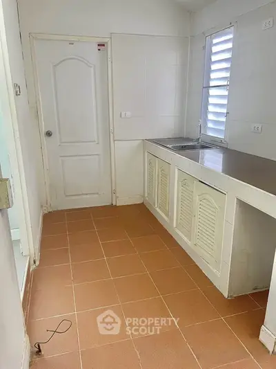 Cozy kitchen with tiled floor and ample counter space in a compact layout.