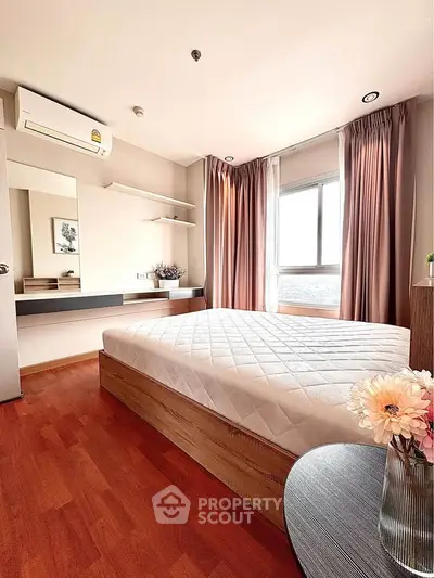 Modern bedroom with large window, wooden flooring, and stylish decor in a high-rise apartment.