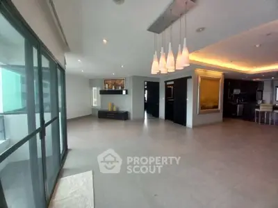 Spacious modern living room with elegant lighting and large windows.