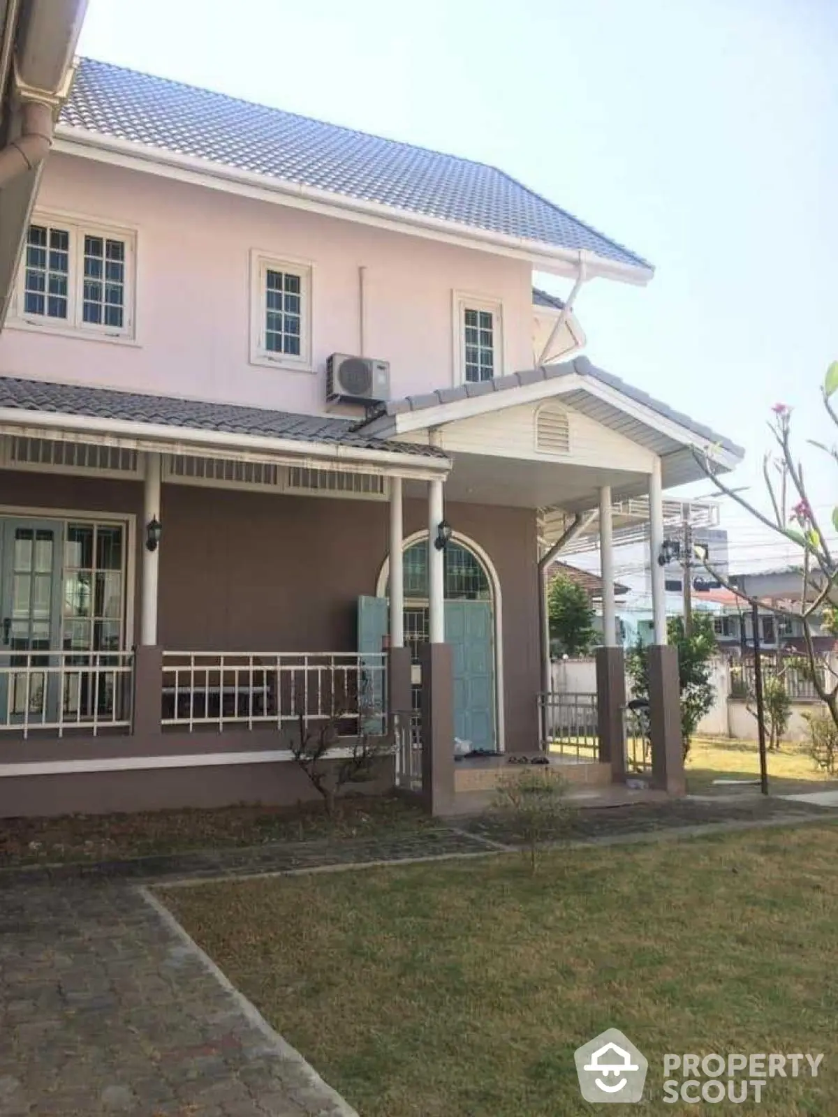 Charming two-story house with manicured lawn and inviting front porch