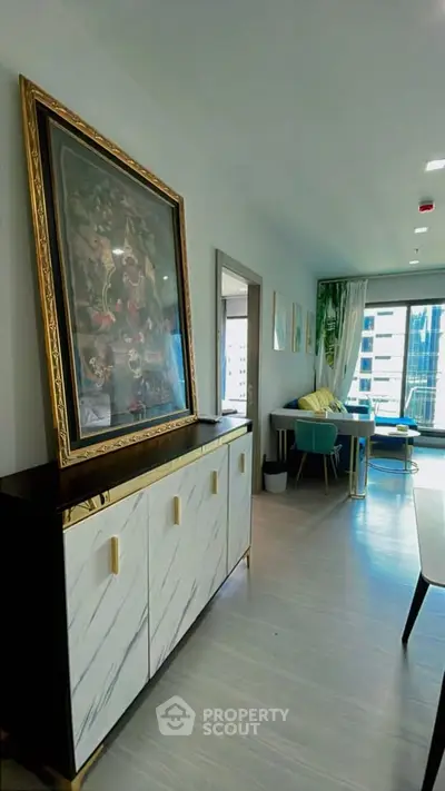 Stylish modern living room with elegant decor and city view, featuring a chic sideboard and vibrant seating area.