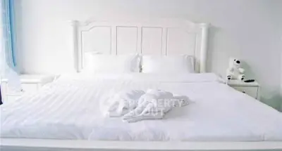 Elegant bedroom with plush white bedding and charming decor for a serene retreat.