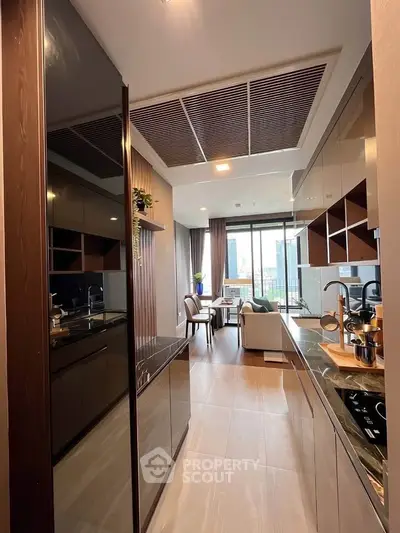 Modern kitchen with sleek cabinetry and open layout leading to a stylish living area with city view.