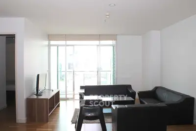 Modern living room with sleek furniture and large windows offering city views.