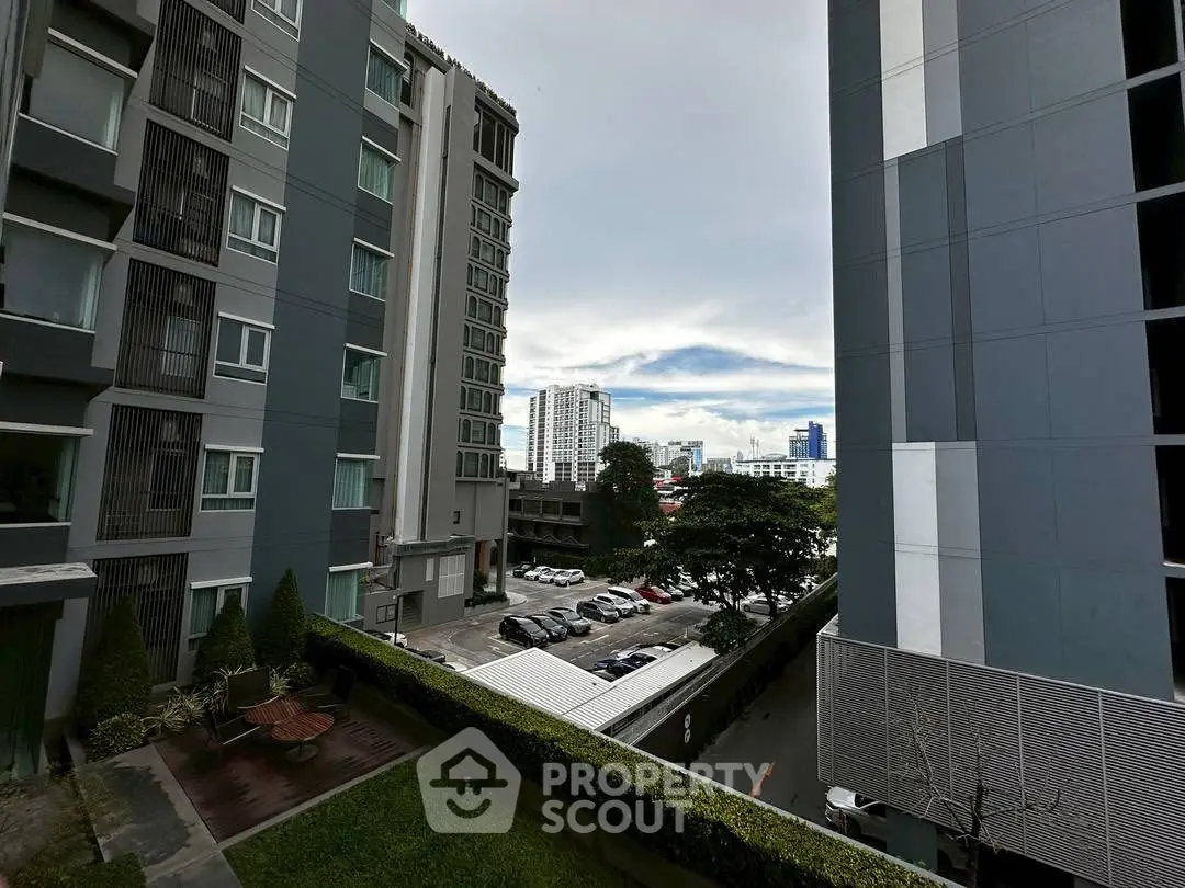 Modern urban apartment buildings with city view and parking area.