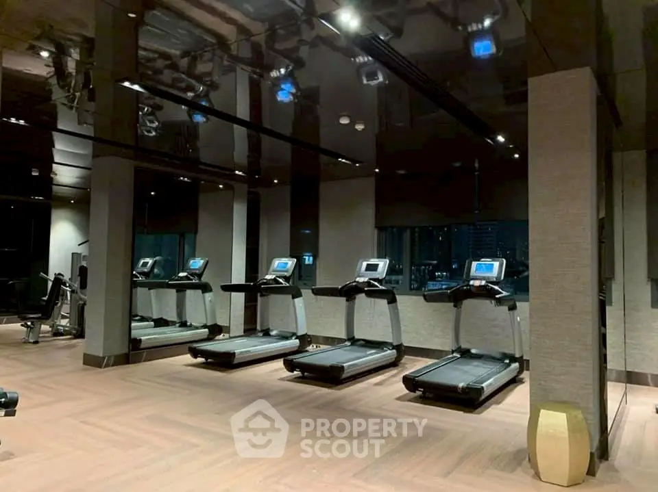 Luxurious gym with modern treadmills and sleek design in upscale residential building.