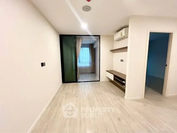 Spacious modern living room with wooden flooring and built-in shelves