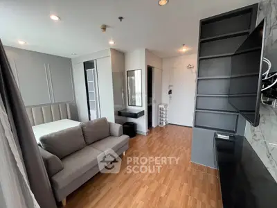 Modern studio apartment with sleek design and cozy furnishings, featuring a comfortable sofa and stylish shelving.