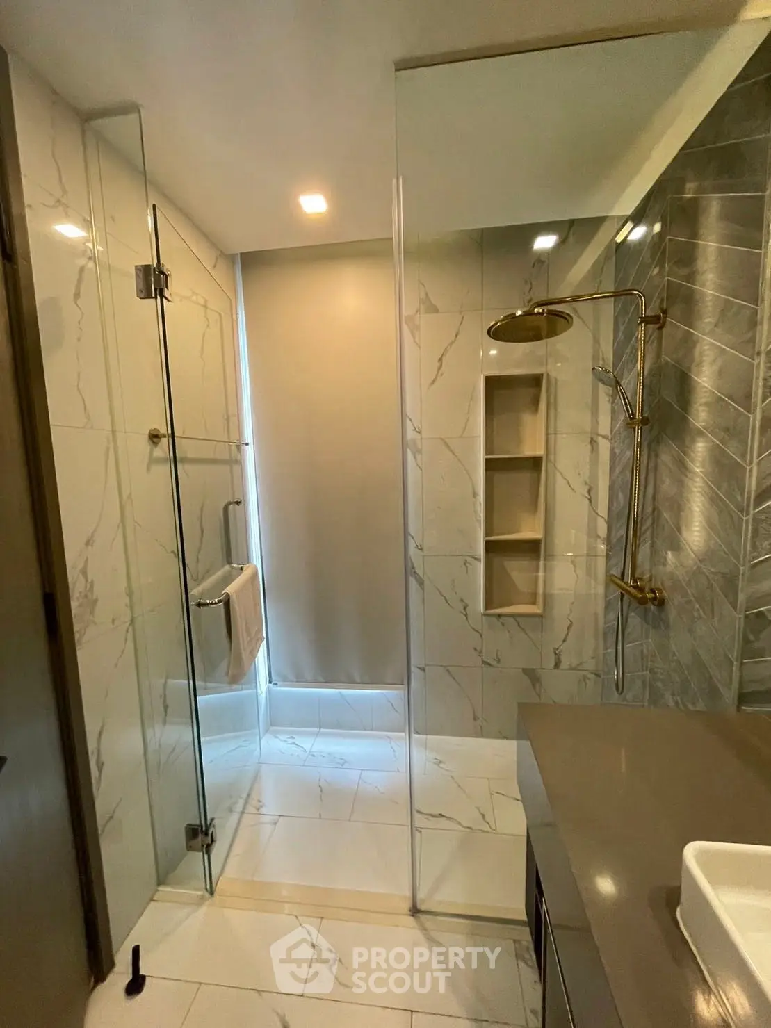 Luxurious modern bathroom with glass shower and marble tiles