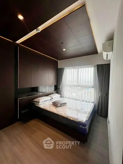 Modern bedroom with sleek design and large window offering natural light