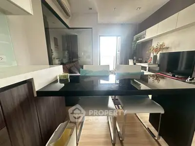 Modern living room with sleek furniture and stylish decor, featuring a glass dining table and contemporary design.