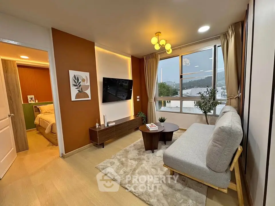 Modern living room with stylish decor and large window offering scenic views.