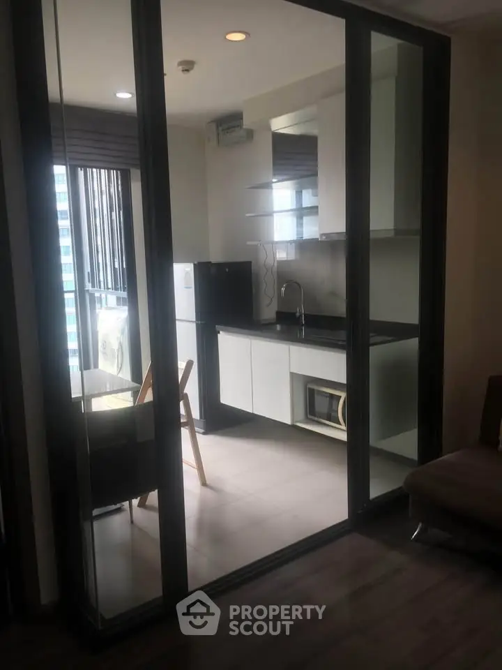 Modern kitchen with sleek design and large windows in a stylish apartment.