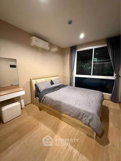 Modern bedroom with cozy bed, wooden flooring, and large window offering serene views.