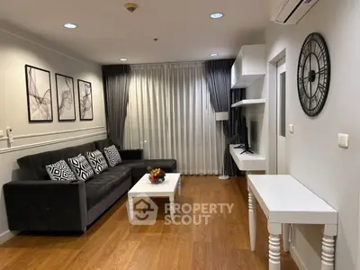 Modern living room with stylish decor, wooden flooring, and elegant furniture in a cozy apartment.