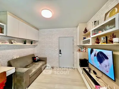 Modern living room with stylish decor and wall-mounted TV, featuring a cozy sofa and sleek storage solutions.