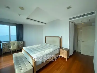 Spacious bedroom with elegant wooden flooring and large window offering stunning views.