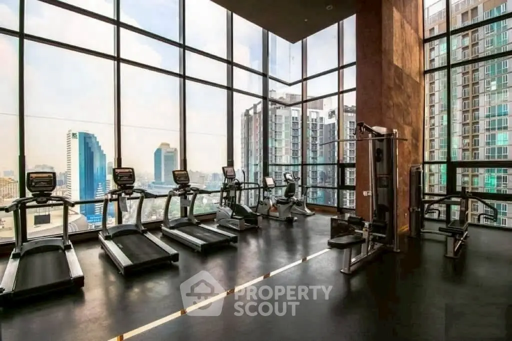 Modern high-rise gym with panoramic city views and state-of-the-art fitness equipment.