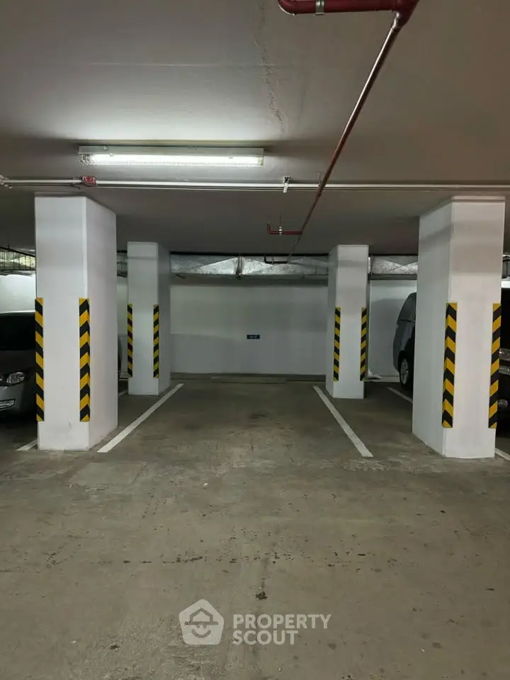 Spacious underground parking area with ample lighting and marked parking spaces.