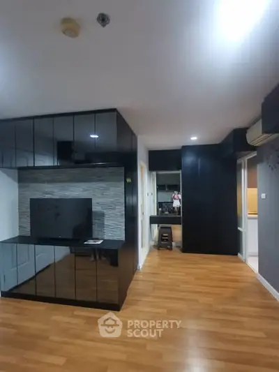 Modern living room with sleek black cabinetry and wooden flooring