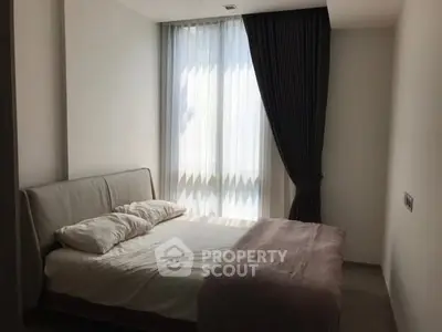 Cozy bedroom with soft lighting and elegant curtains, perfect for relaxation.