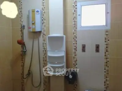 Modern bathroom with shower and tiled walls, featuring a window for natural light.