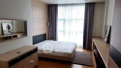 Spacious bedroom with large window and modern furnishings, perfect for comfort and relaxation.
