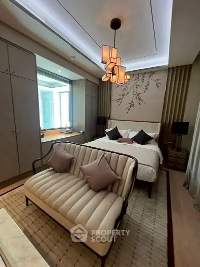 Luxurious bedroom with elegant decor and stylish lighting, featuring a cozy seating area and modern furnishings.