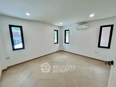 Spacious and bright room with modern windows and air conditioning, perfect for a cozy living space.