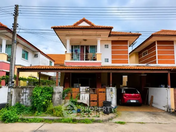 Charming two-story house with red-tiled roof and carport in a suburban neighborhood.