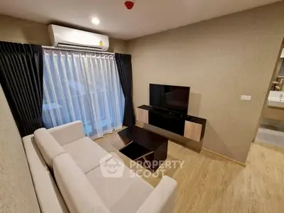 Modern living room with sleek furniture and large window for natural light.